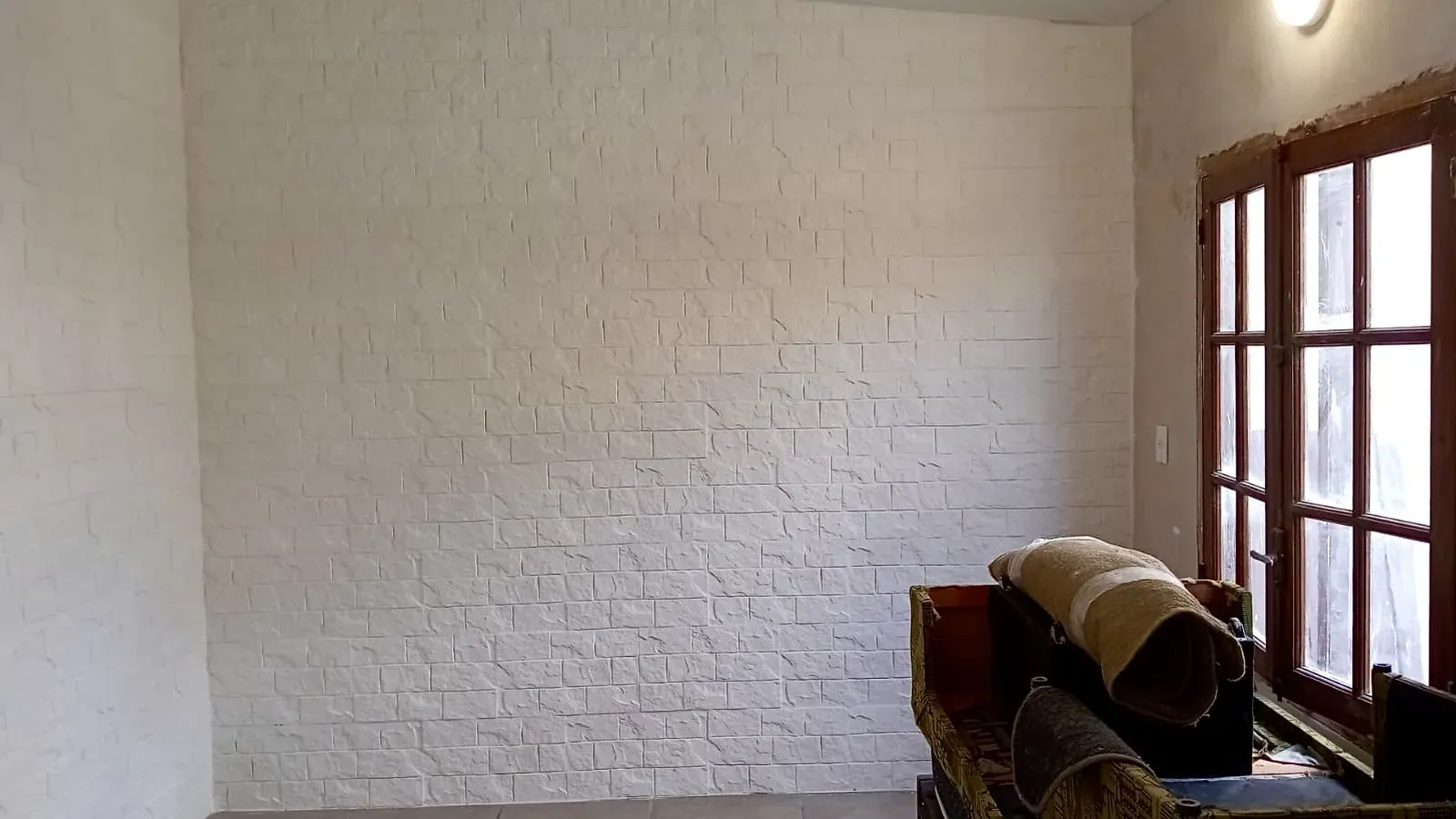 La misma pared seca y renovada con placas de yeso símil ladrillo
